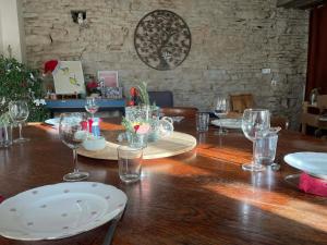 a wooden table with wine glasses on top of it at Cense des Possibles, Forêt et Prairie in Darcey