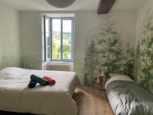 a bedroom with a bed with two stuffed animals on it at Cense des Possibles, Forêt et Prairie in Darcey