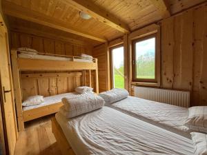 a bedroom with two beds in a wooden house at Ethno holistic village Apače - Nature Retreat in Slovenia in Apače