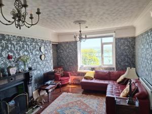 a living room with a couch and a fireplace at Moon River in Goodwick