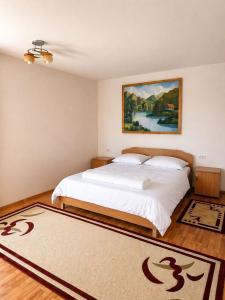 a bedroom with a bed with a painting on the wall at Casa Marinca in Ocna Şugatag