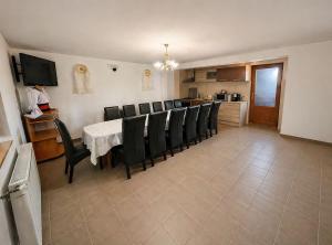 a dining room with a table and black chairs at Casa Marinca in Ocna Şugatag
