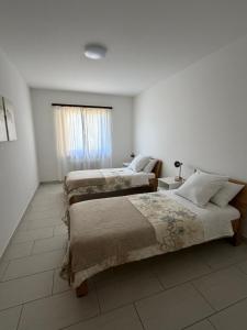 a bedroom with two beds and a window at Appartamento sole in Isone