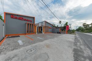 a red board store on the side of a street at RedDoorz Plus at Orange Diponogoro Palangkaraya in Palangkaraya