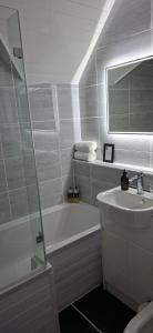 a bathroom with a sink and a tub and a mirror at Derrybeg Bed and Breakfast in Pitlochry +29 photos
