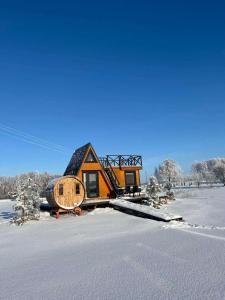 a house in the middle of a snow covered field at Liepų namelis - Linden Shore in Miroslavas +4 photos