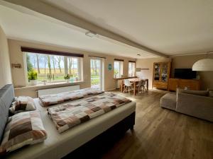 a bedroom with a large bed and a living room at Fewo Sort Sol - Auszeit in perfekter Alleinlage in Aventoft
