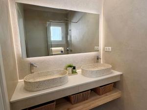 two sinks in a bathroom with a large mirror at Vicky's Panoramic View Apartments in Pelekas