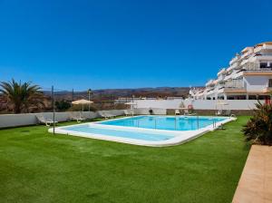 a swimming pool in a yard next to a building at Incredible Sunsets in Puerto Rico de Gran Canaria