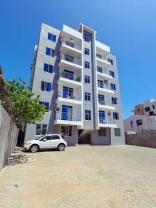 a car parked in front of a tall building at Kenya coast stays in Nyali