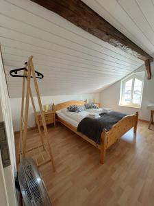 a bedroom with a wooden bed in a attic at Nimbuzzz Apartments in Unterseen