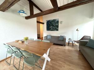 a living room with a wooden table and chairs at Nimbuzzz Apartments in Unterseen +38 photos