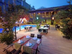 an outdoor patio with tables and chairs and a pool at Oscar Boutique Hotel in Antalya