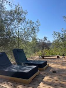 two chairs sitting on top of a wooden deck at Secluded design cabin forest retreat in Cyprus in Kappedhes