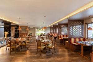 a restaurant with tables and chairs in a room at Hotel Imphal by the Classic in Imphal