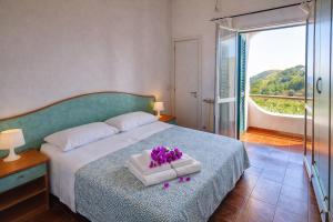 a bedroom with a bed with purple flowers on it at Hotel Bellavista in Sant'Angelo D'Ischia
