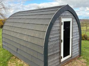 a large gambrel shed with a window at Hillside Pod in Oswestry