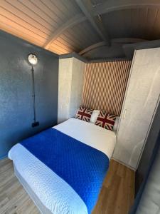 a bedroom with a blue and white bed in a room at Lake View Retreats in Rickmansworth