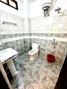 a bathroom with a toilet and a sink at Hotel Suryavansham in Gupta Kāshi