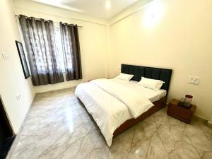 a bedroom with a large bed and a window at Hotel Suryavansham in Gupta Kāshi +7 photos