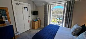 a bedroom with a bed and a large window at Derrybeg Bed and Breakfast in Pitlochry