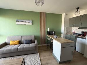 a living room with a couch and a kitchen at Studio côté soleil in Saint-Jean-de-Monts