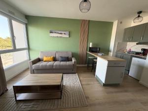 a living room with a couch and a table at Studio côté soleil in Saint-Jean-de-Monts +11 photos