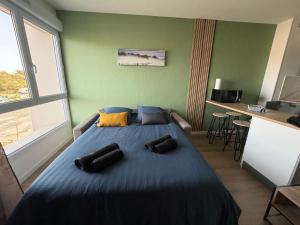 a bedroom with a large blue bed with pillows on it at Studio côté soleil in Saint-Jean-de-Monts