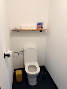 a bathroom with a toilet with a shelf on the wall at L Amy-Côtier in Saint-Pierre-dʼOléron