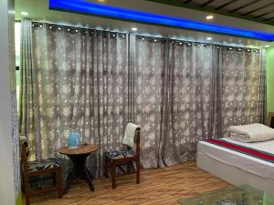 a bedroom with a bed and a table and a chair at Hotel Best Ocean in Kathmandu