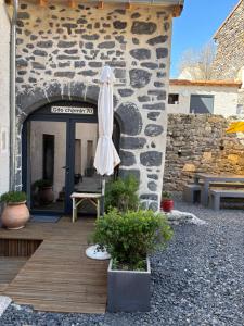 an umbrella sitting outside of a stone building at En si bon chemin - Gîte d'étape chemin 70 in Le Monastier sur Gazeille