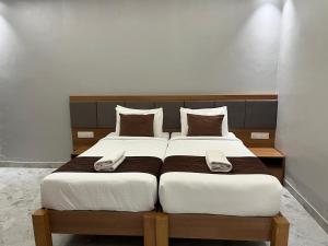 a bedroom with two beds with white sheets at Sancara Business Hotel in Jāmb