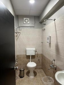 a bathroom with a toilet and a sink at Sancara Business Hotel in Jāmb