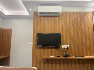 a room with a tv on a wooden wall at Sancara Business Hotel in Jāmb