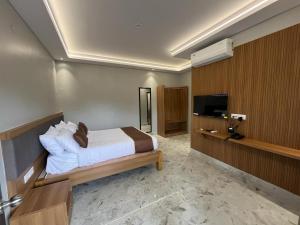 a hotel room with a bed and a television at Sancara Business Hotel in Jāmb