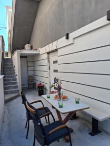 a patio with a table and chairs and stairs at Apartman Golden Stone in Ivanica