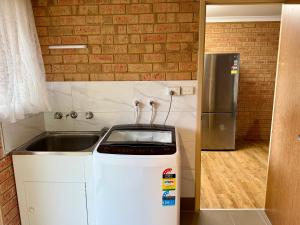 a small kitchen with a sink and a refrigerator at Good price Apartment self check-in in Geraldton