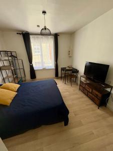 a bedroom with a bed and a flat screen tv at Pause Confort Studio idéal centre ville in Gravelines
