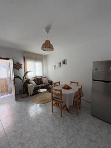a living room with a table and a refrigerator at El paraíso in Raxó