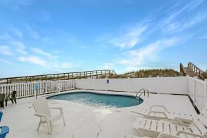a swimming pool on a patio with chairs and a table at Beach Blessing by Pristine Property Vacation Rentals in Cape San Blas