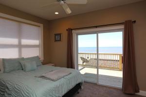 a bedroom with a bed and a sliding glass door at Buckleys Beach House by Pristine Property Vacation Rentals in Indian Pass