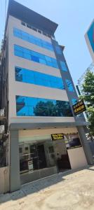 a tall building with blue windows on it at Apex Inn Gulf View in Bangalore