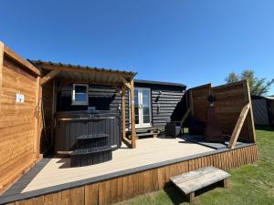 a backyard deck with a grill and a house at Lake View Retreats in Rickmansworth