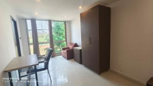 a room with a table and a chair and a cabinet at Apex Inn Gulf View in Bangalore