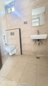a bathroom with a toilet and a sink at Apex Inn Gulf View in Bangalore +12 photos
