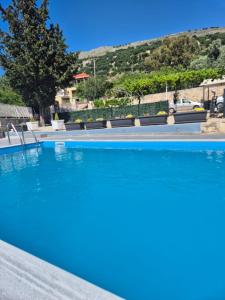 a swimming pool with blue water in front of a house at Casa di Pietro 2 in Fársa