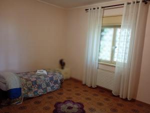 a bedroom with a bed and a window and a rug at Santi Palace Apartment in Gravina di Catania +11 photos
