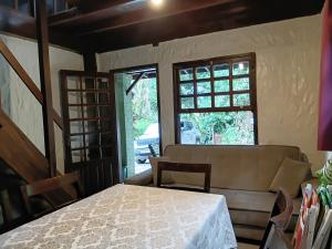 a dining room with a table and a window at Apartamentos do Centrinho do Rosa in Imbituba