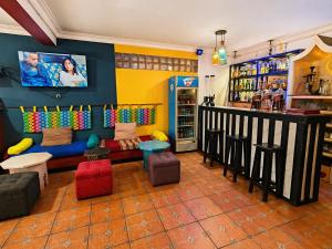 a bar with a couch andools in a room at Hôtel la medina in Antananarivo