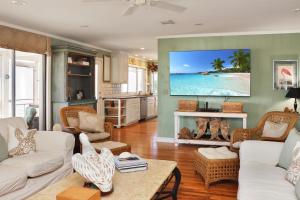 a living room with a large screen tv over a fireplace at White Pelican by Pristine Property Vacation Rentals in Indian Pass